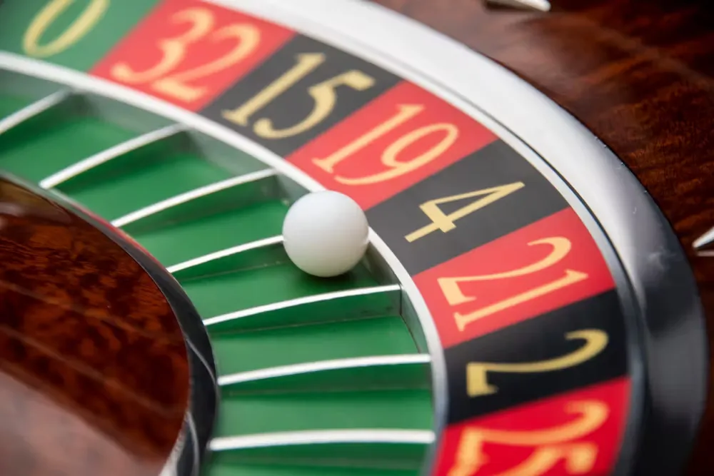 A sophisticated gaming lounge featuring a concentrated player at a roulette wheel — elite 99XO visuals.